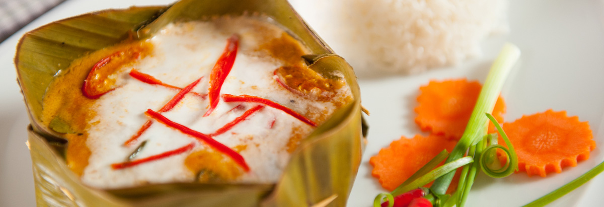 Fish amok served in a banana-leaf cup with rice